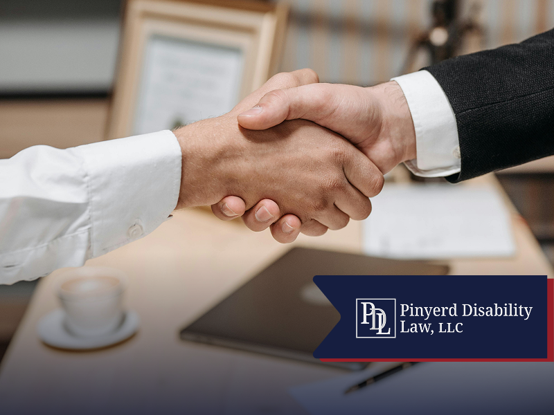 Close-up of a handshake at a desk