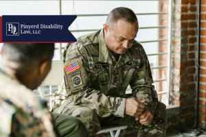 Service member looking down with hands clasped during a group session