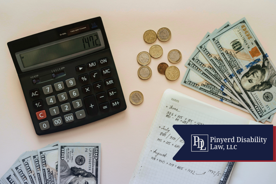 Calculator, cash, coins and a notebook of monthly totals