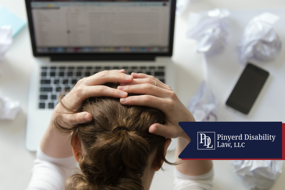Woman at her desk holding her head in frustration