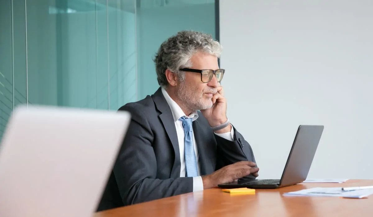 Self-employed professional on a phone call while reviewing his laptop