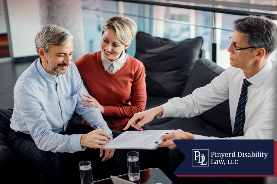 Couple signing paperwork with an advisor on a couch