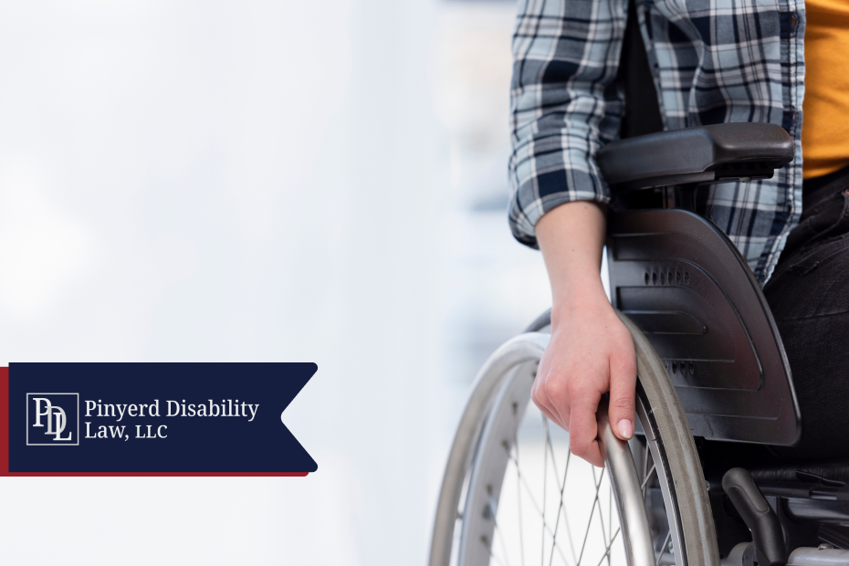 Person seated in a wheelchair with a hand on the wheel