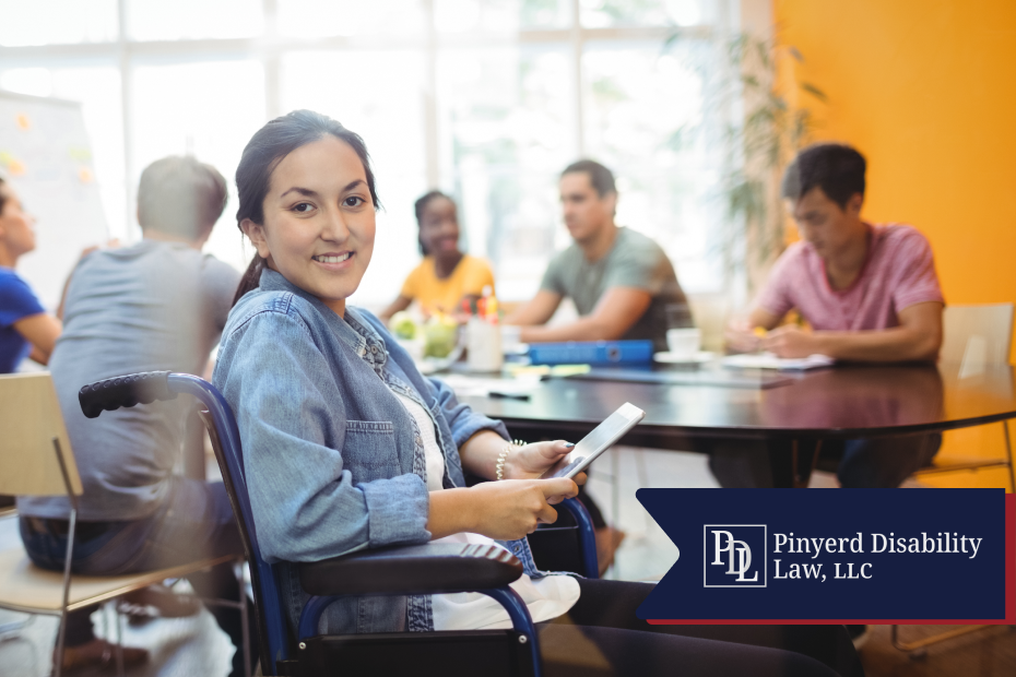 Smiling woman in a wheelchair holding a tablet in a meeting room