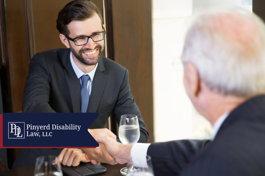 Attorney smiling and shaking hands with an older client