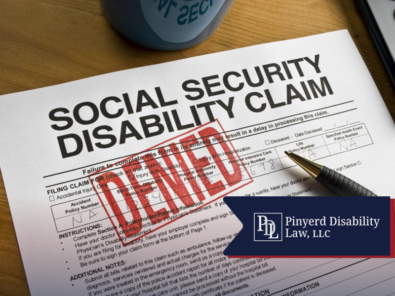 Denied Social Security disability claim form with a pen